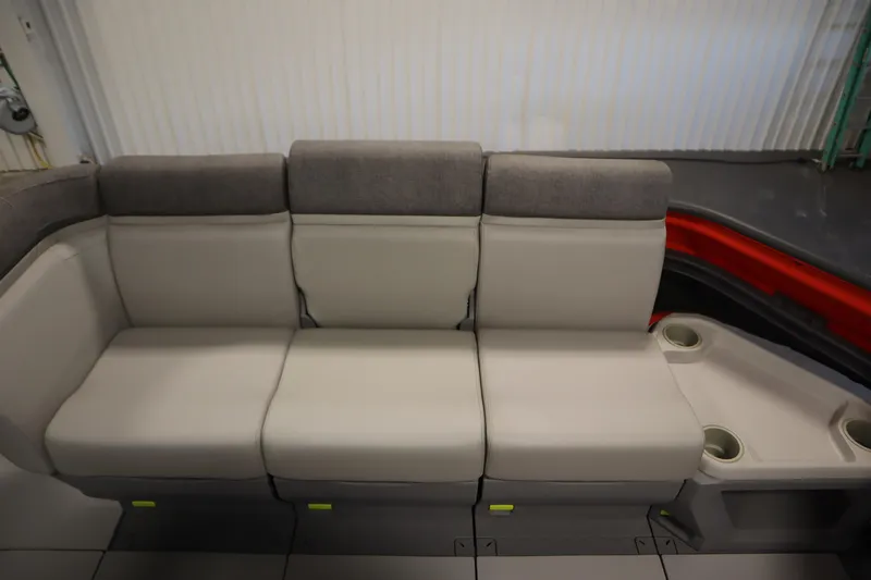 Slide: The Image of 2024 Sea-Doo Switch Cruise 21 interior seating with cup holders, featuring gray and beige upholstery. - 11