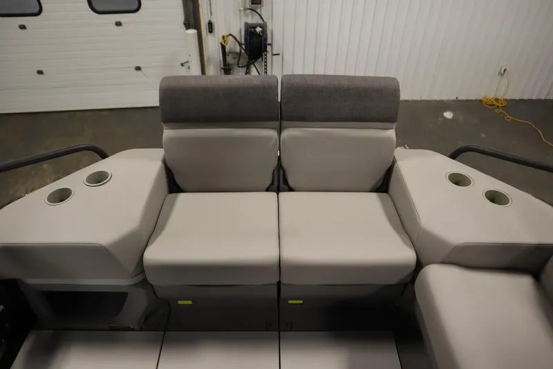 Slide: The Image of 2024 Sea-Doo Switch Cruise 21 interior seating with cup holders in a garage setting. - 28