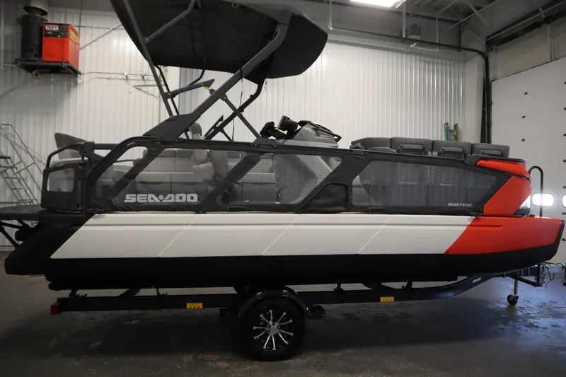 Slide: The Image of 2024 Sea-Doo Switch Cruise 21 pontoon boat in a garage setting. - 3