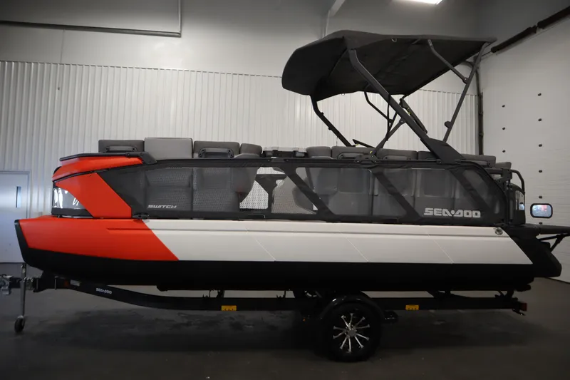 Slide: The Image of 2024 Sea-Doo Switch Cruise 21 pontoon boat in a showroom, side view. - 7