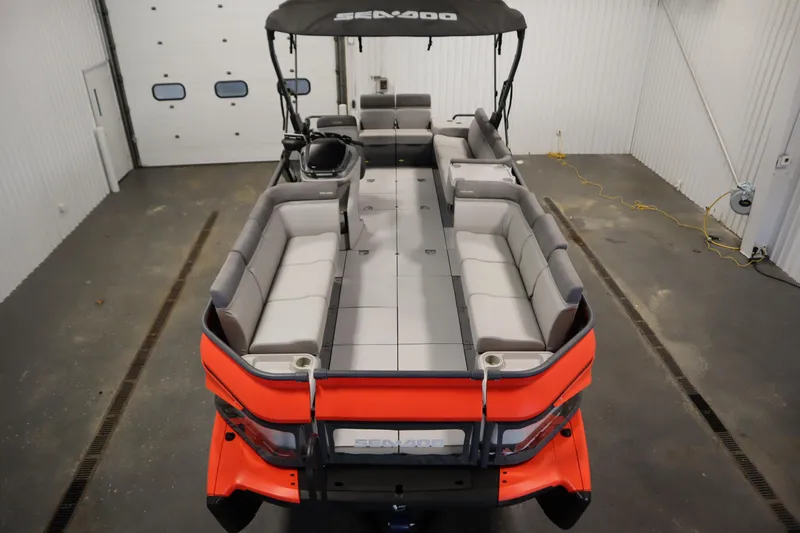 Slide: The Image of 2024 Sea-Doo Switch Cruise 21 pontoon boat with spacious seating in a garage. - 8