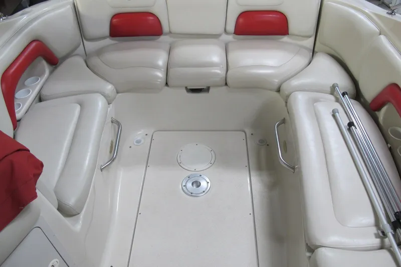 Slide: The Image of 2003 Crownline 270 BR boat interior with cream and red seating, cup holders, and metal handles. - 7