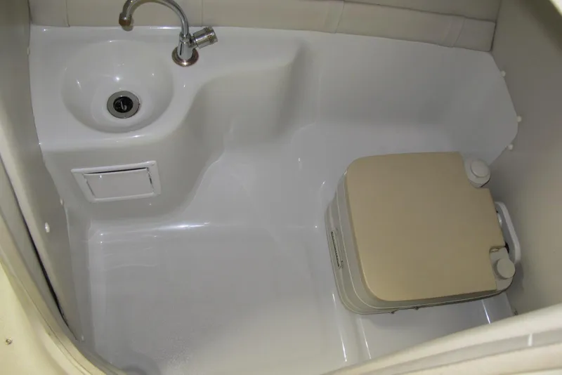 Slide: The Image of Compact bathroom in 2003 Crownline 270 BR boat with sink and portable toilet. - 9