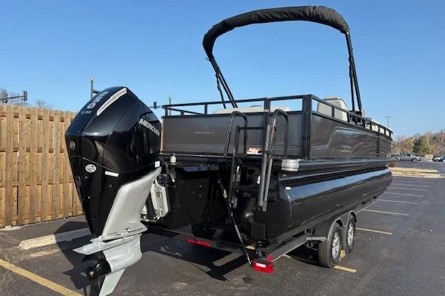 Slide: The Image of 2025 Regency 250 DL3 pontoon boat with Mercury outboard engine, parked on a trailer. - 14
