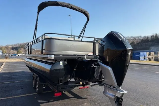Slide: The Image of 2025 Regency 250 DL3 pontoon boat with outboard motor in a parking lot. - 17