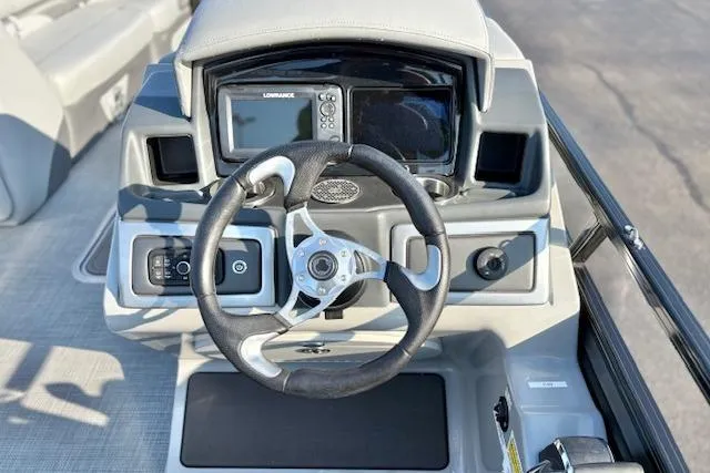 Slide: The Image of 2025 Regency 250 DL3 boat dashboard with steering wheel and navigation system. - 28