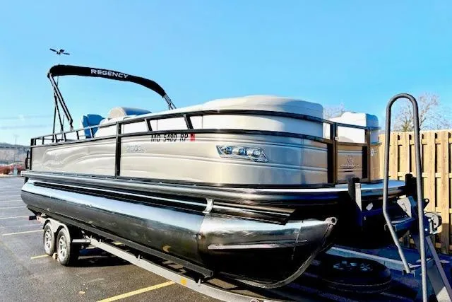Slide: The Image of 2025 Regency 250 DL3 pontoon boat on trailer in parking lot. - 3