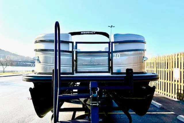 Slide: The Image of 2025 Regency 250 DL3 pontoon boat on trailer, parked outdoors. - 4