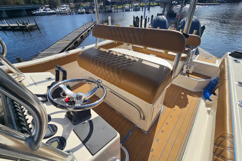 Slide: The Image of 2006 Key West 268 Center Console boat interior with brown seating and steering wheel. - 10