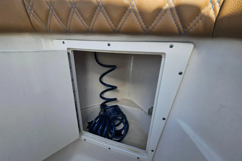 Slide: The Image of Storage compartment with coiled blue hose on 2006 Key West 268 Center Console boat. - 22