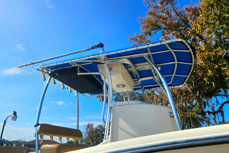 Slide: The Image of 2006 Key West 268 Center Console boat with blue canopy under clear sky. - 24