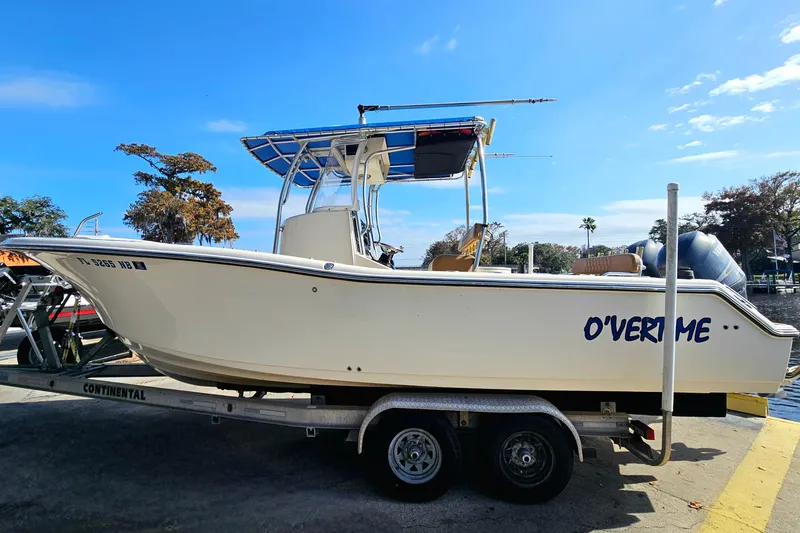Slide: The Image of 2006 Key West 268 Center Console boat on trailer, named "O'Vertime," under clear blue sky. - 26