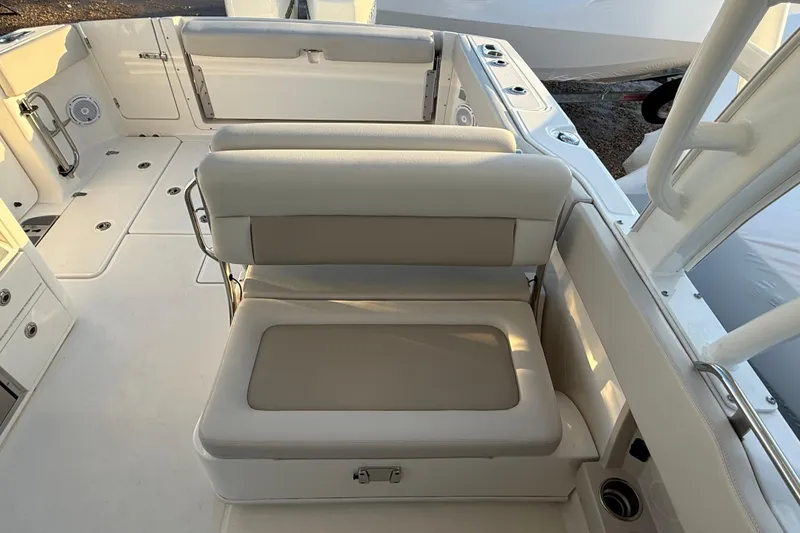 Slide: The Image of 2017 Boston Whaler 320 Vantage boat interior with cushioned seating and storage compartments. - 24