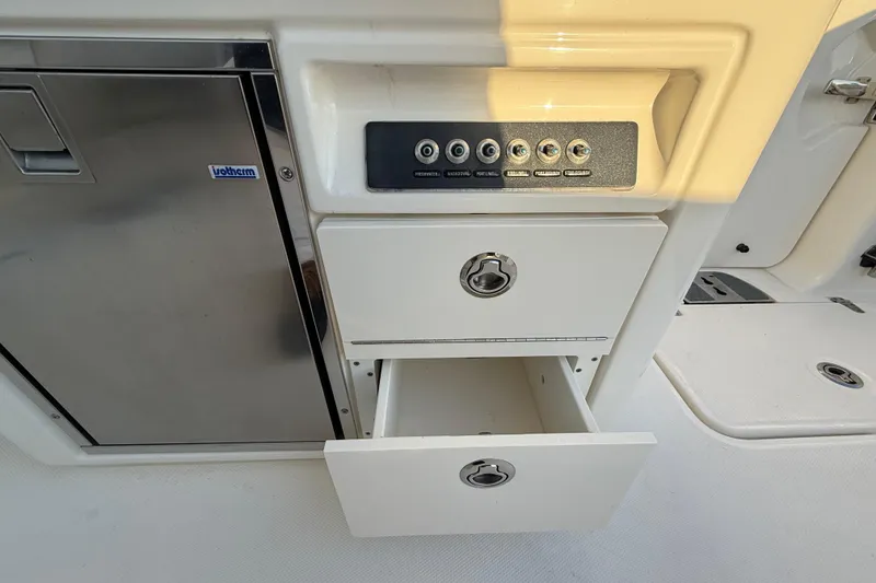 Slide: The Image of Control panel and storage drawers on a 2017 Boston Whaler 320 Vantage boat. - 27