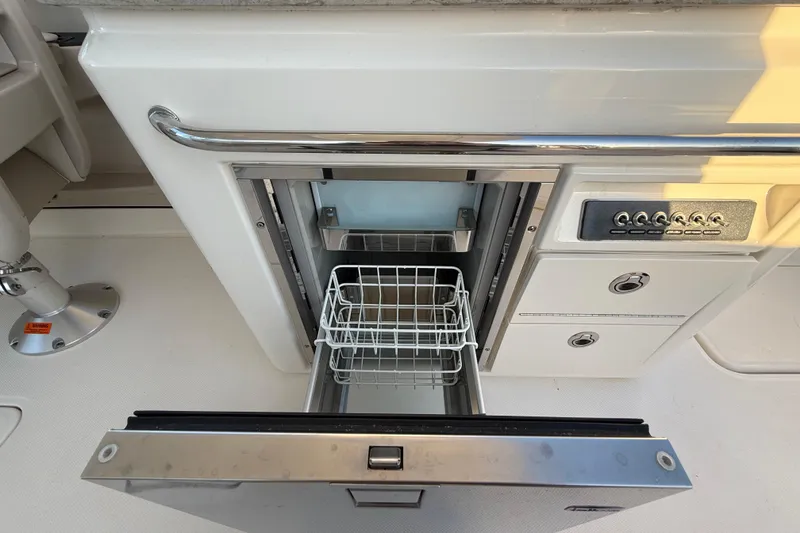 Slide: The Image of 2017 Boston Whaler 320 Vantage boat interior with open drawer and control panel. - 28