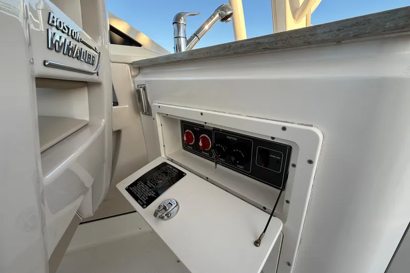 Slide: The Image of 2017 Boston Whaler 320 Vantage control panel with ignition switches and faucet. - 32