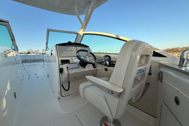 Slide: The Image of 2017 Boston Whaler 320 Vantage boat cockpit with steering wheel and seating. - 36