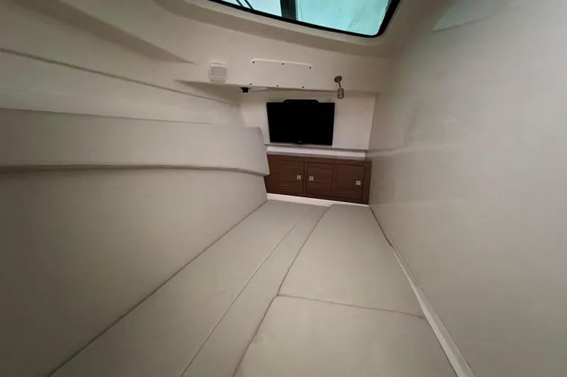 Slide: The Image of Interior cabin of 2017 Boston Whaler 320 Vantage with cushioned seating and storage. - 45