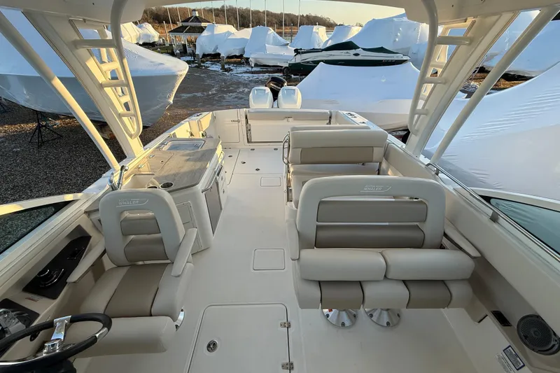 Slide: The Image of 2017 Boston Whaler 320 Vantage boat interior with seating and helm, docked outdoors. - 47