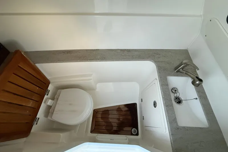Slide: The Image of 2017 Boston Whaler 320 Vantage boat bathroom with toilet and sink. - 51