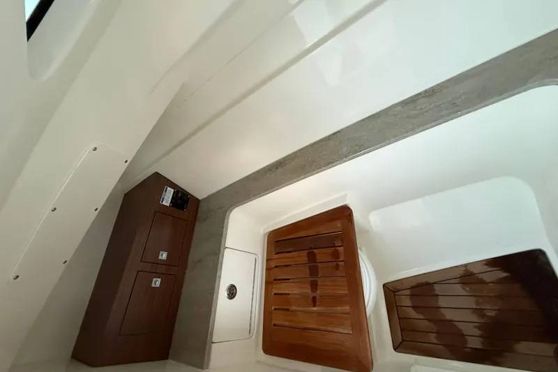 Slide: The Image of 2017 Boston Whaler 320 Vantage interior with wooden accents and storage compartments. - 53