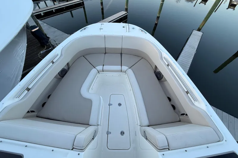 Slide: The Image of 2017 Boston Whaler 320 Vantage boat interior with cushioned seating at dock. - 56
