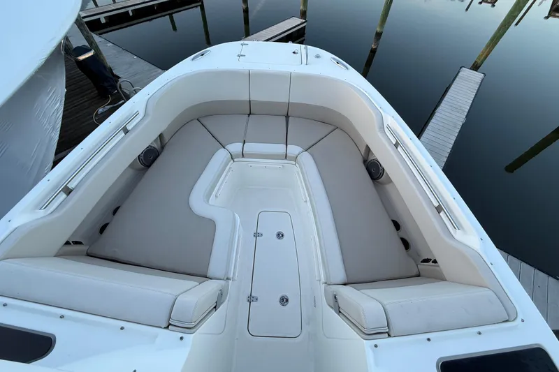 Slide: The Image of 2017 Boston Whaler 320 Vantage boat interior with cushioned seating at dock. - 57