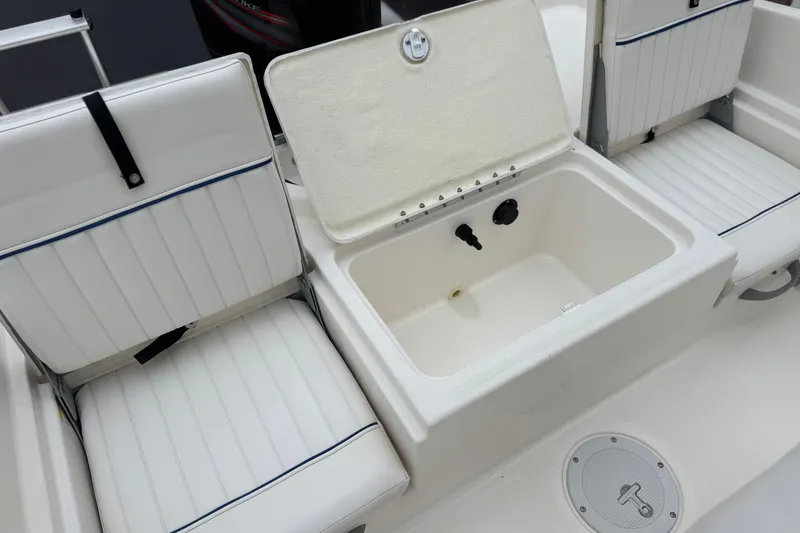 Slide: The Image of 2017 Bayliner Element F18 boat interior with open storage compartment and cushioned seats. - 18