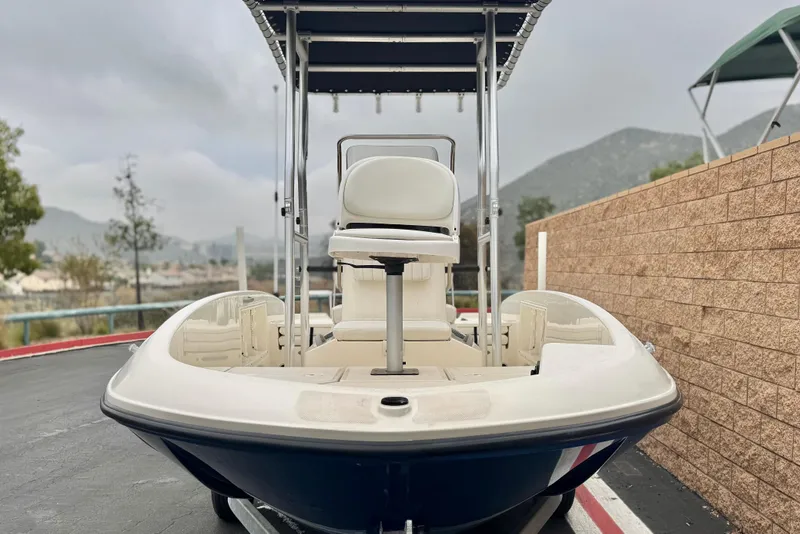 Slide: The Image of 2017 Bayliner Element F18 boat with T-top, parked on a paved surface. - 2