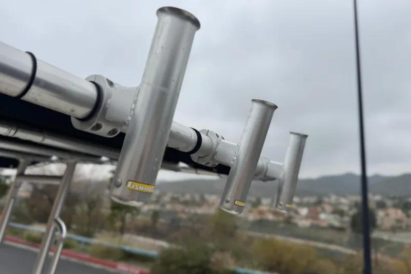 Slide: The Image of Rod holders on a 2017 Bayliner Element F18 boat, with a cloudy sky backdrop. - 23