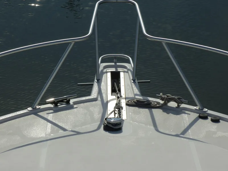 Slide: The Image of Cabo 40 Express 2005 boat with cushioned seating, overlooking serene waters and a distant bridge. - 32