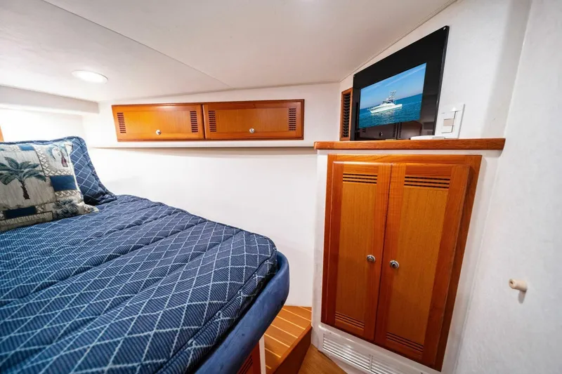 Slide: The Image of Luxurious cabin interior of 2005 Cabo 40 Express yacht with cozy bedding and wooden cabinetry. - 41