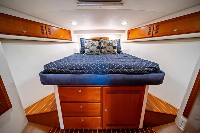 Slide: The Image of Luxurious cabin interior of 2005 Cabo 40 Express yacht with cozy bed and wooden storage. - 45