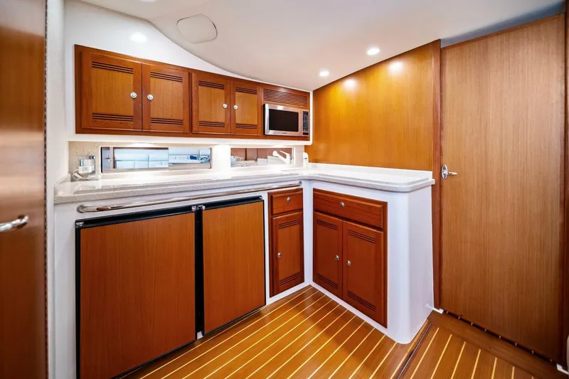 Slide: The Image of Luxurious 2005 Cabo 40 Express yacht interior with wooden cabinetry and modern amenities. - 49