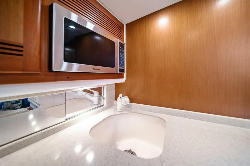Slide: The Image of 2005 Cabo 40 Express yacht kitchen with microwave and sink. - 50