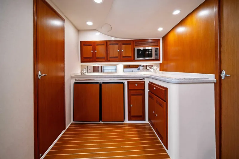 Slide: The Image of 2005 Cabo 40 Express yacht interior with wooden cabinets and modern kitchen amenities. - 54