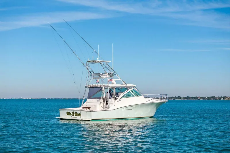 Slide: The Image of 2005 Cabo 40 Express boat on calm blue water under clear sky. - 63