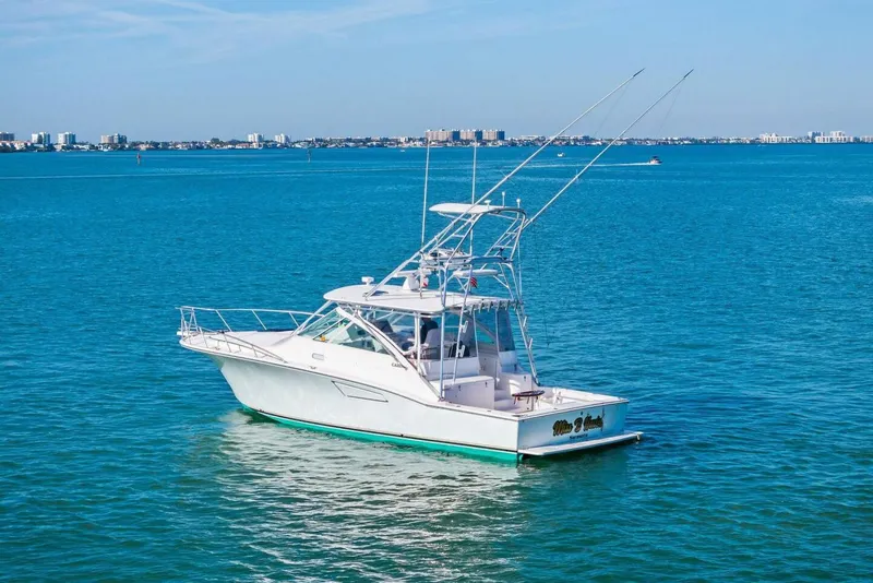 Slide: The Image of 2005 Cabo 40 Express yacht on calm blue waters under clear sky. - 70
