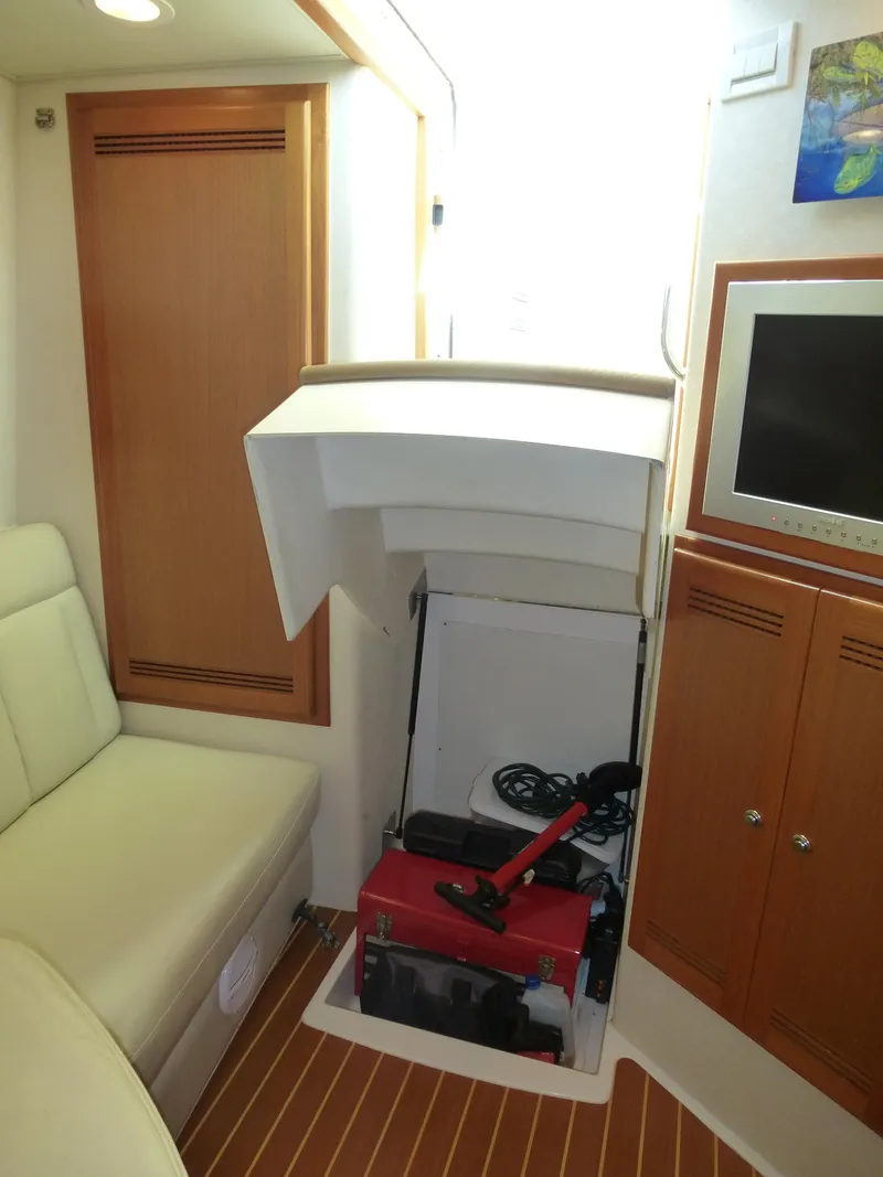 Slide: The Image of 2005 Cabo 40 Express boat interior with white captain's chair and storage cabinets. - 8