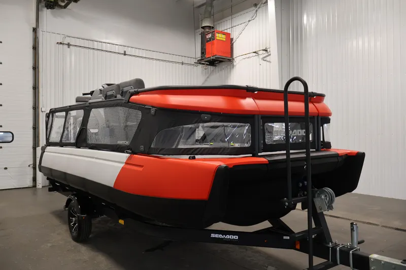 Slide: The Image of 2024 Sea-Doo Switch 19 pontoon boat in a garage, showcasing sleek design and enclosed seating. - 2