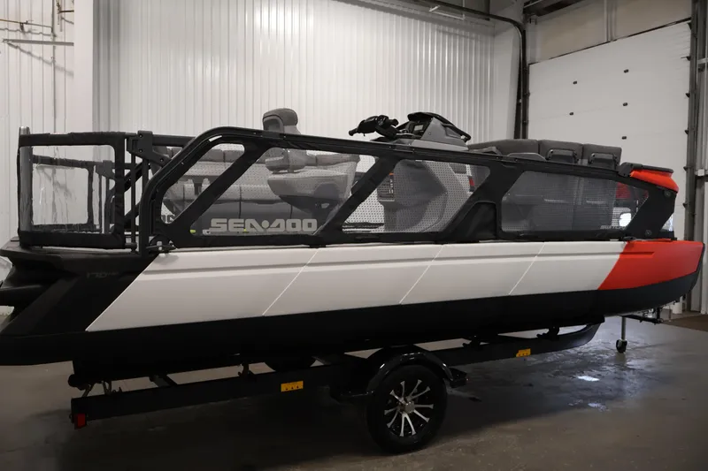 Slide: The Image of 2024 Sea-Doo Switch 19 pontoon boat in a garage, rear view. - 3
