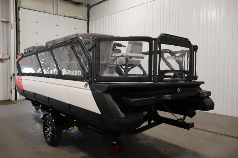 Slide: The Image of 2024 Sea-Doo Switch 19 pontoon boat in a garage, rear view. - 6