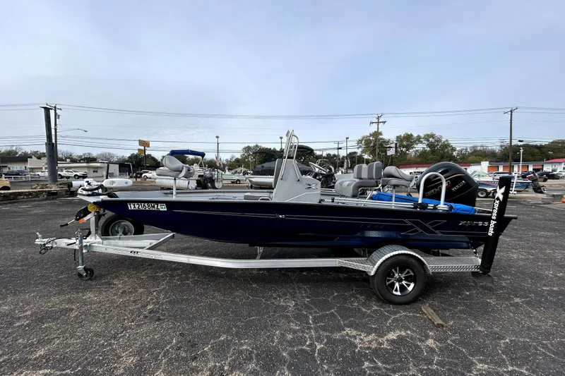 Slide: The Image of 2025 Xpress H20B Bay boat on trailer in parking lot. - 4