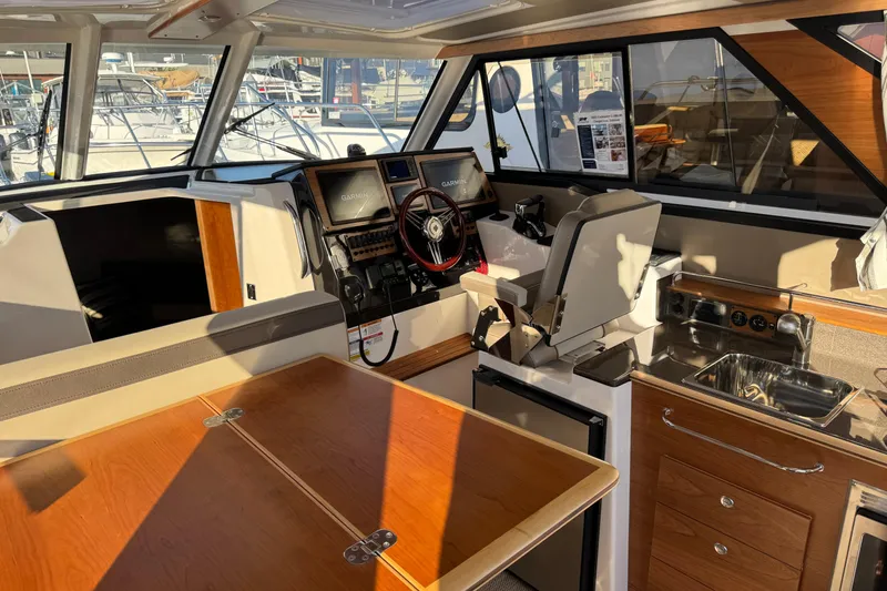 Slide: The Image of Interior of 2025 Cutwater C-288 Coupe boat with helm, seating, and kitchenette. - 13