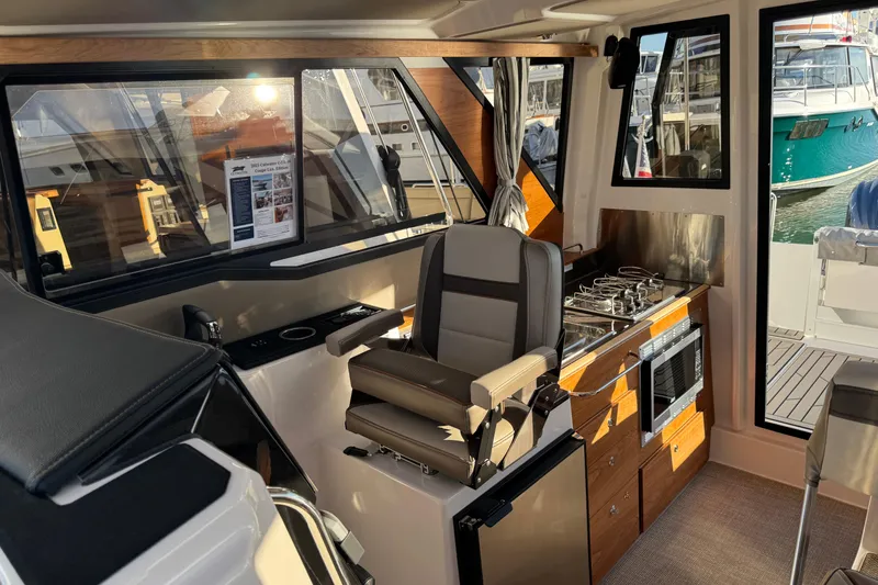 Slide: The Image of Interior of 2025 Cutwater C-288 Coupe with helm, kitchen, and seating area. - 15