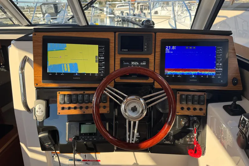 Slide: The Image of Helm of 2025 Cutwater C-288 Coupe with Garmin navigation displays and wooden steering wheel. - 17