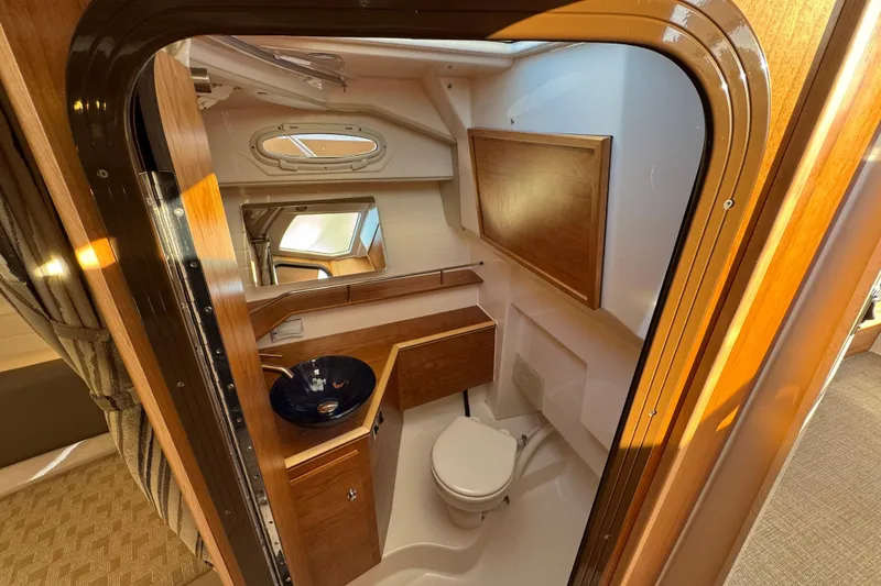 Slide: The Image of 2025 Cutwater C-288 Coupe bathroom with wooden cabinetry and modern fixtures. - 24