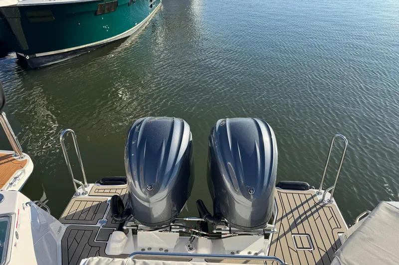 Slide: The Image of 2025 Cutwater C-288 Coupe with dual outboard engines on a calm water surface. - 7