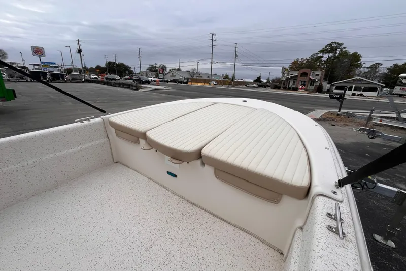 Slide: The Image of 2019 Carolina Skiff 20 JVX CC boat with cushioned seating, parked near a road. - 10