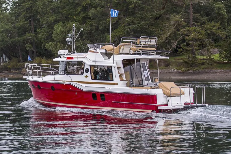 Slide: The Image of Manufacturer Provided Image: 2025 Ranger Tugs R-29 CB cruising on a serene lake with lush forest backdrop. - 3